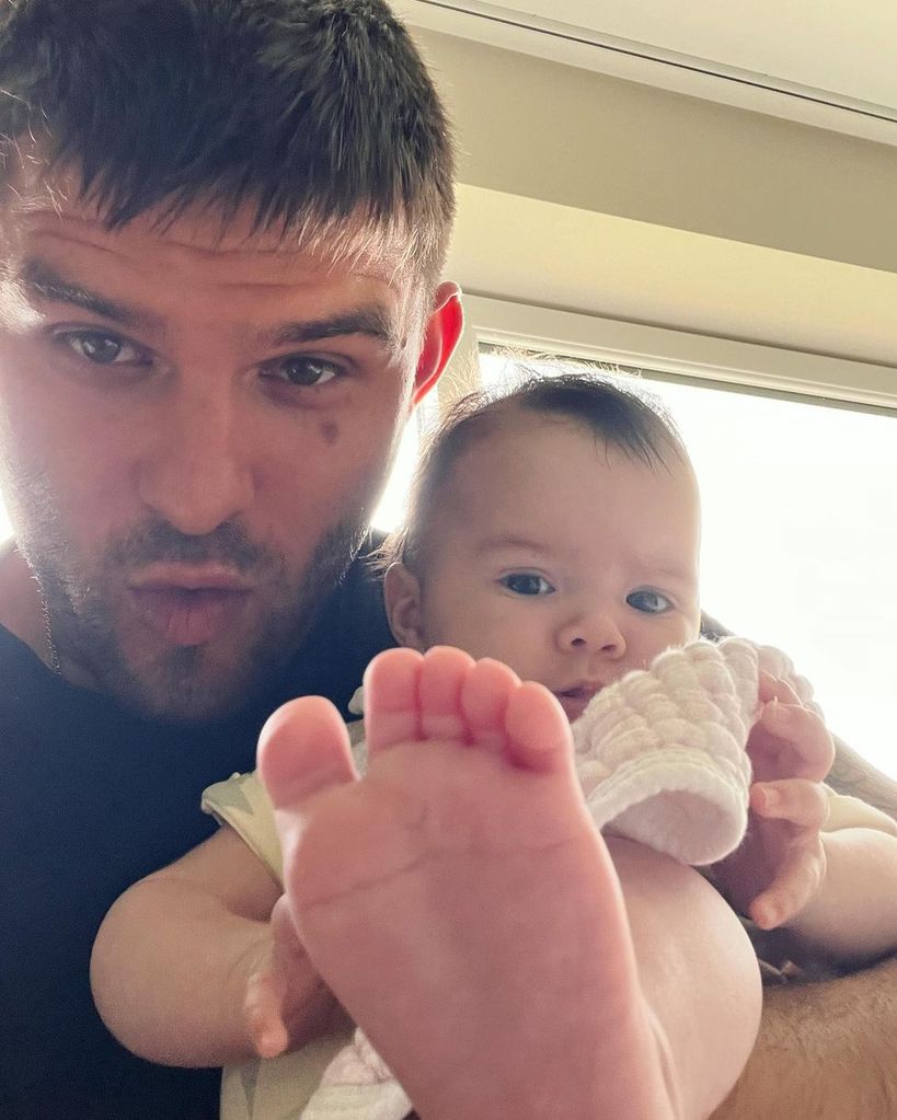 Aljaz Skorjanec holds daughter Lyra up to the camera as she points her toes