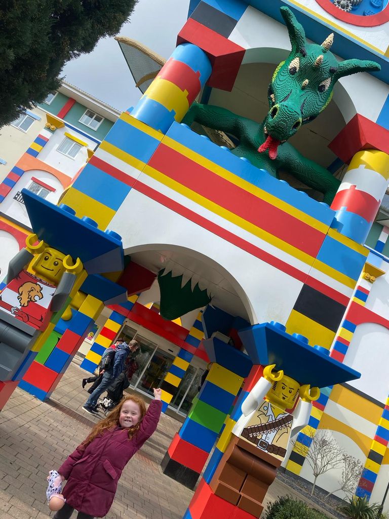 Little girl pointing at a Lego dragon