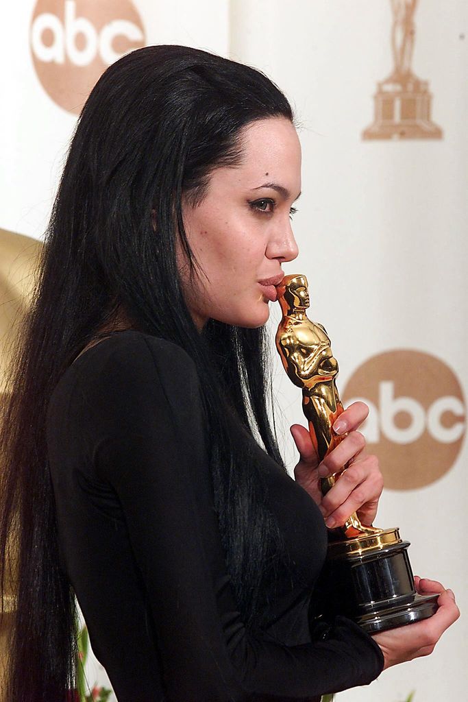 Angelina Jolie kisses her Oscar at the Academy Awards in Los Angeles 26 March 2000. Jolie won for Best Supporting Actress for her role in "Girl Interupted". 