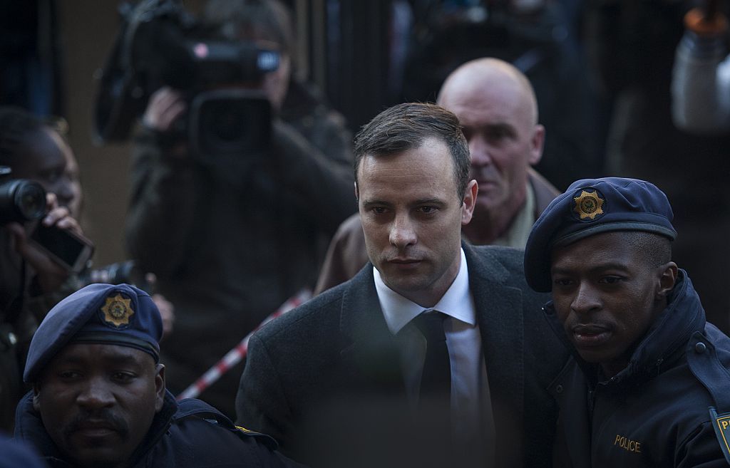PRETORIA, SOUTH AFRICA - JULY 06:  South African Paralympic athlete Oscar Pistorius arrives with security at the North Gauteng High Court to attend summary judgement on his trial on July 6, 2016 in Pretoria, South Africa.The Paralympic athlete killed his girlfriend on Valentines Day of 2013, when he fired a gun four times through a locked toilet door at his Pretoria home. (Photo by Chris Jude/Anadolu Agency/Getty Images)
