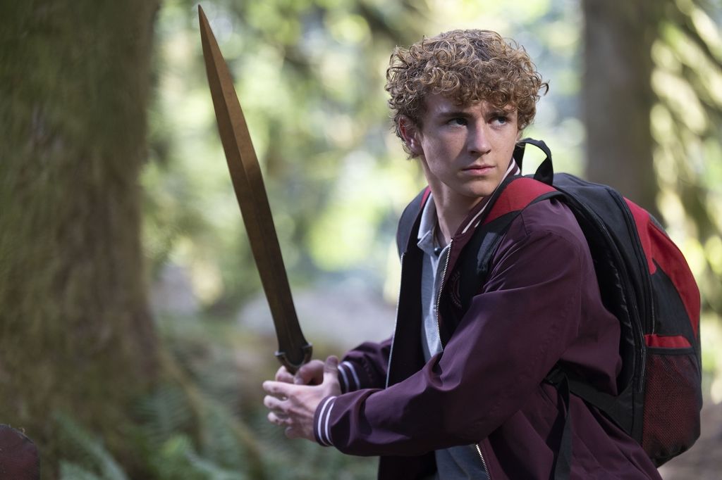 teen boy holding sword in woodland