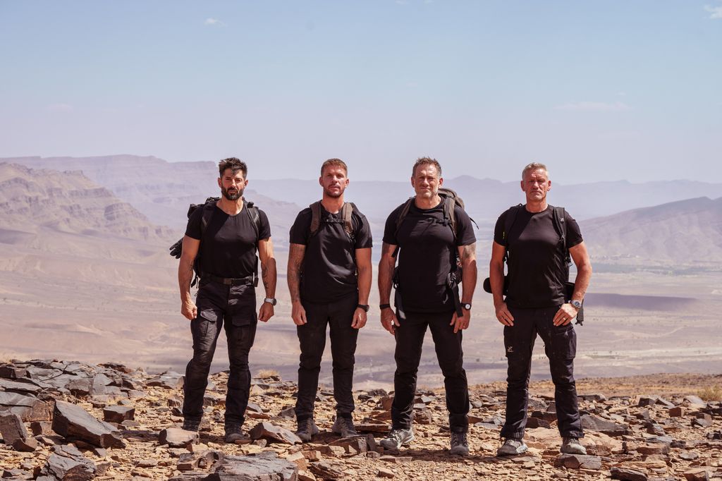 four men standing on mountain 