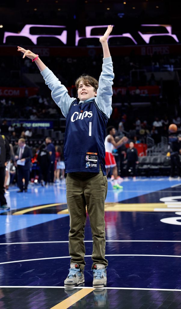 Alicia Silverstone's son, Bear Blu, shoots a basketball prior to the start of a basketball game 