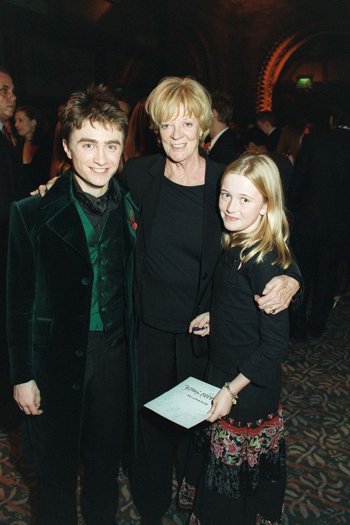 Daniel Radcliffe standing with Dame Maggie Smith and one of her granddaughters