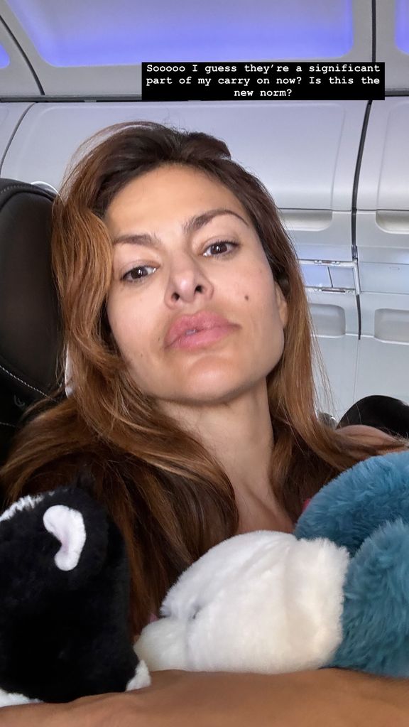 eva mendes holding daughters stuffed animals on a plane