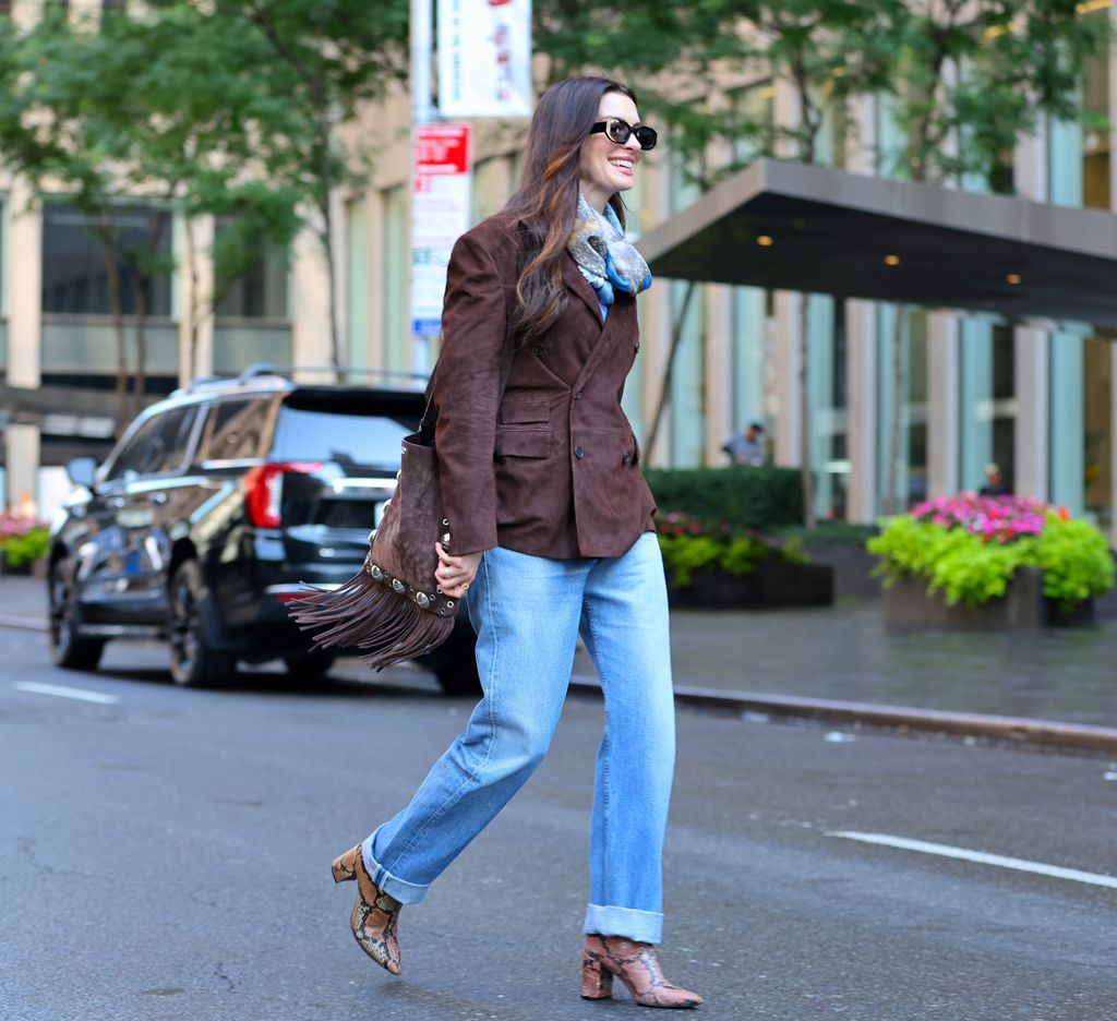 Anne Hathaway brown suede jacket, snakeskin boots, on The Devil Wears Prada 2