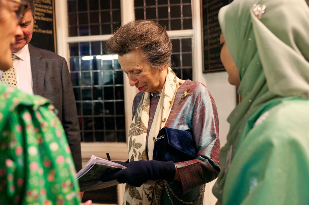 La princesa Ana se vistió con su tela metálica mientras firma un libro 
