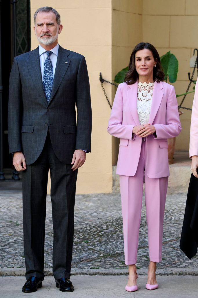 Queen Letizia in lilac fitted suit standing with felipe