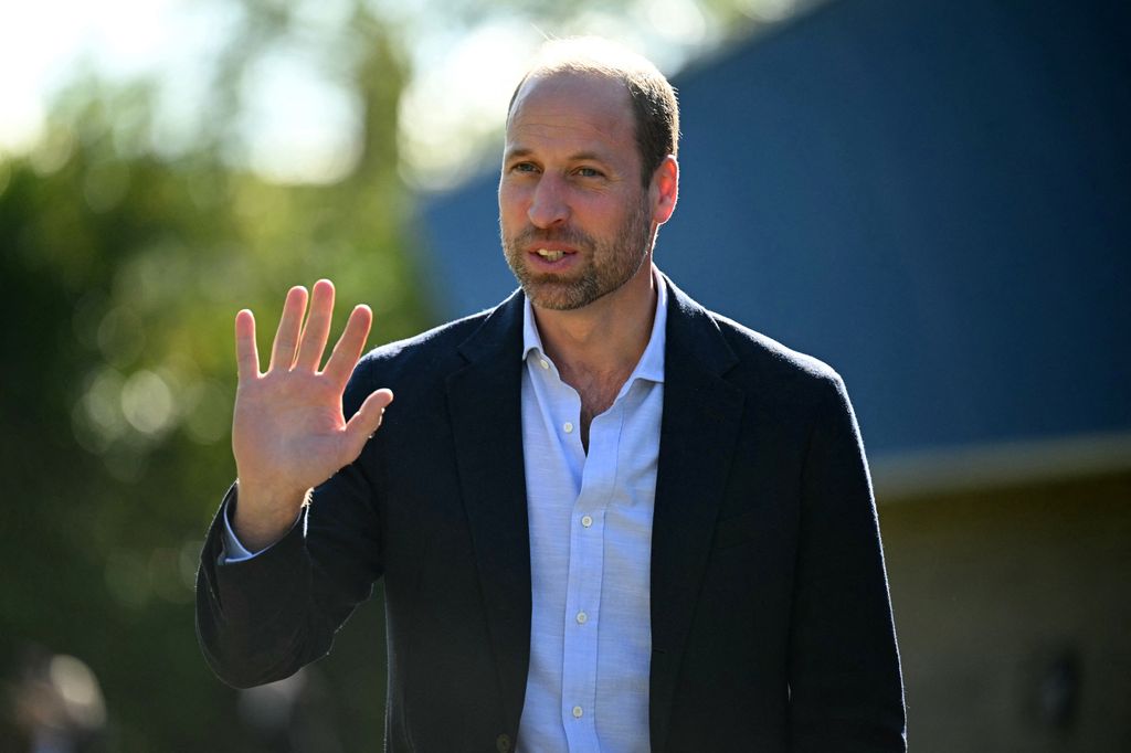 Prince William outside in a blue shirt and suit jacket