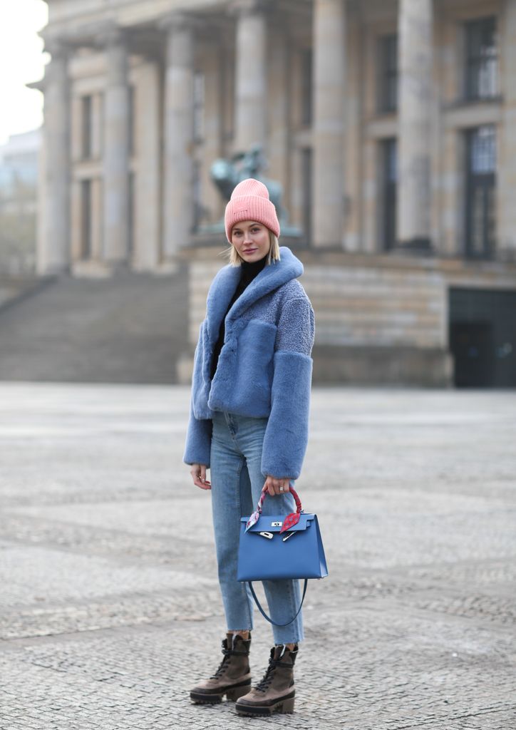 Mandy Bork in Berlin wearing a blue faux fr jacket, skinny jeans, a blue Hermes handbag and brown hiking boots