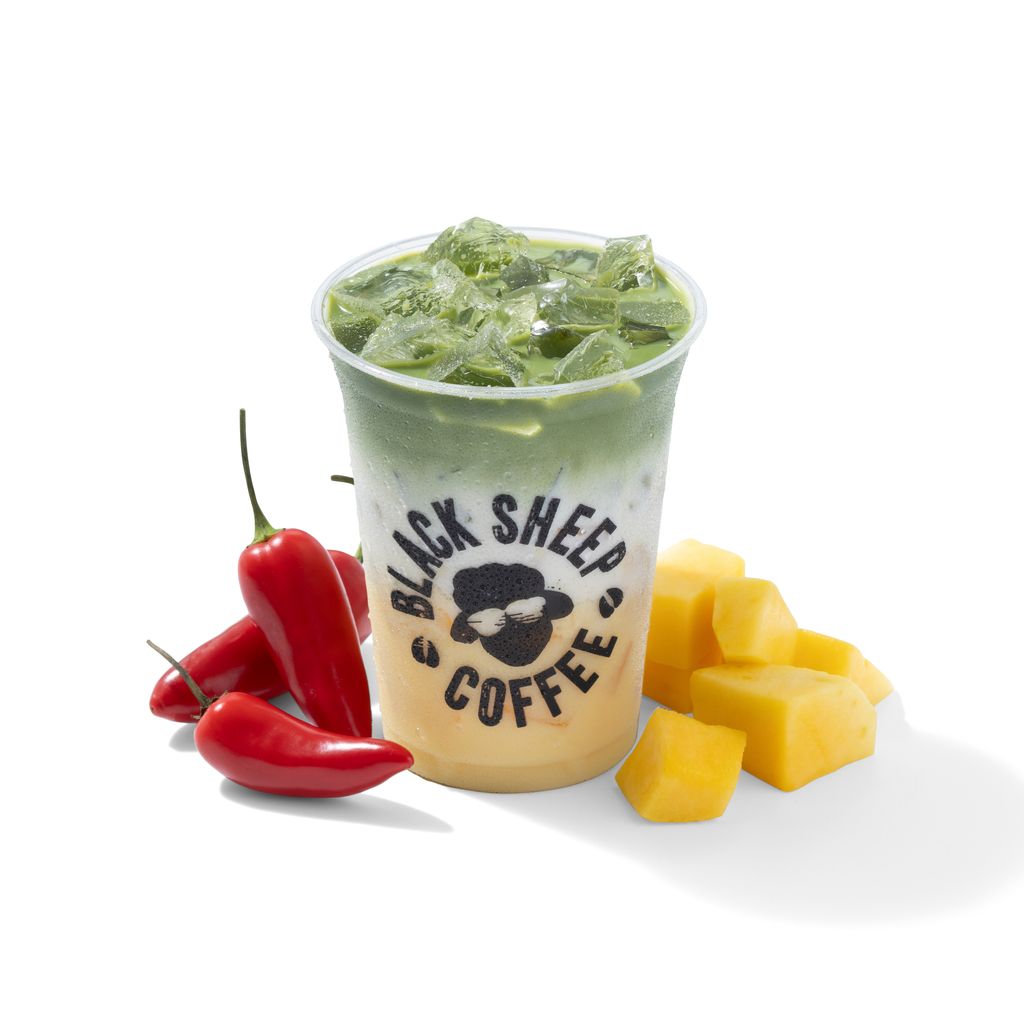 Drinks container with an orange and green drink surrounded by chillies and mango chunks