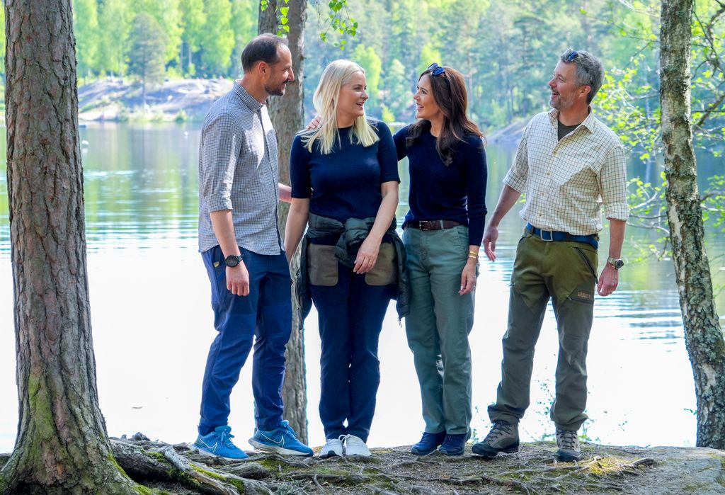 Crown Prince Haakon, Crown Princess Mette-Marit, Queen Mary and King Frederik stand by the water on a walk around the Ulsrudvann lake