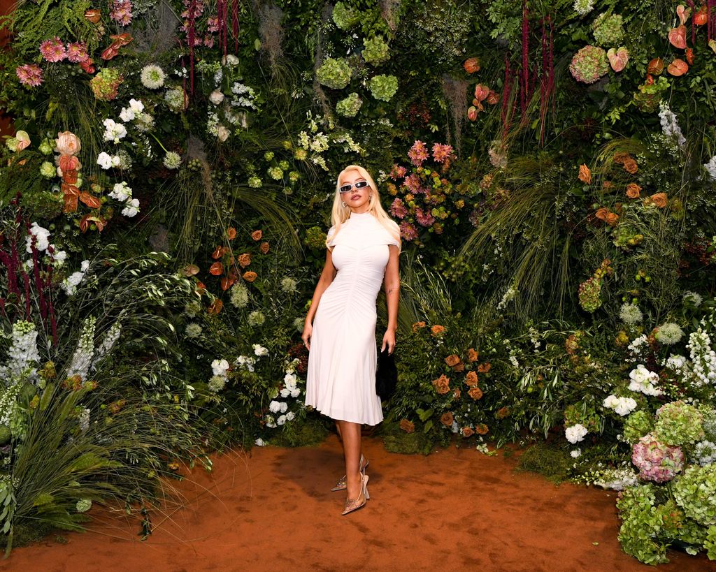 Christina Aguilera wears white dress that poses in front of plants and trees