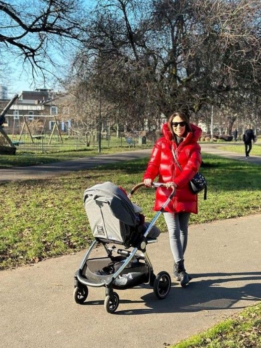 Alex beams as she pushes daughter Annie