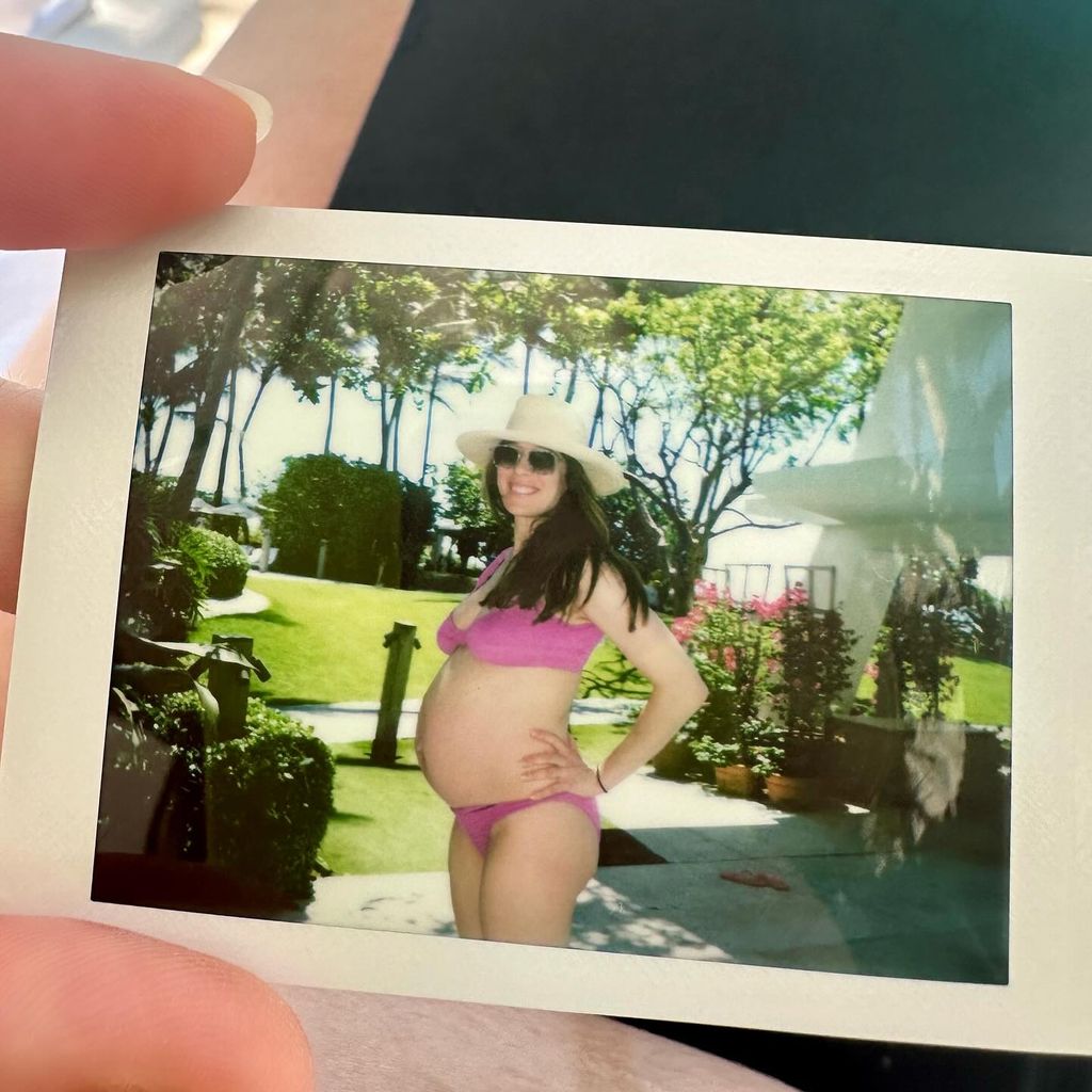 Marina Squerciati holding a Polaroid photo of herself pregnant 