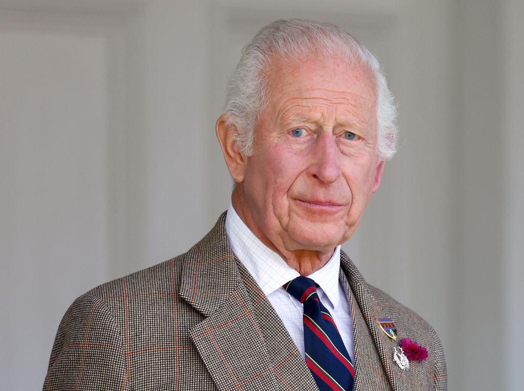 King Charles looking concerned in a tartan suit