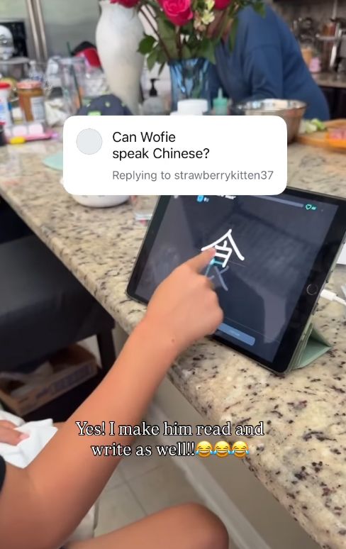 Un jeune garçon sur une tablette dessinant des caractères chinois