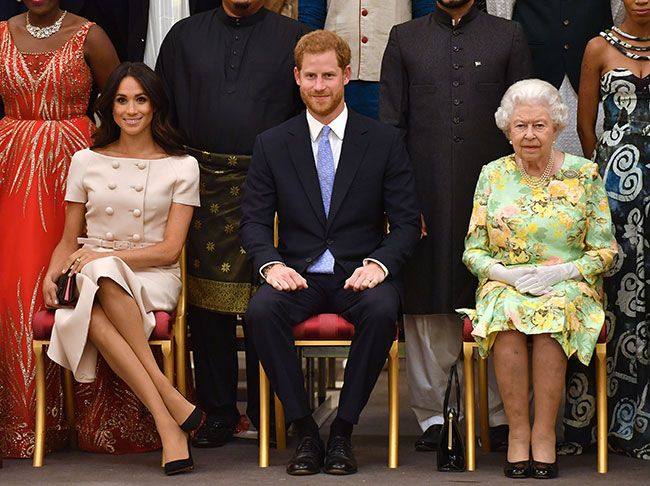The Queen posing with Prince Harry and Meghan Markle