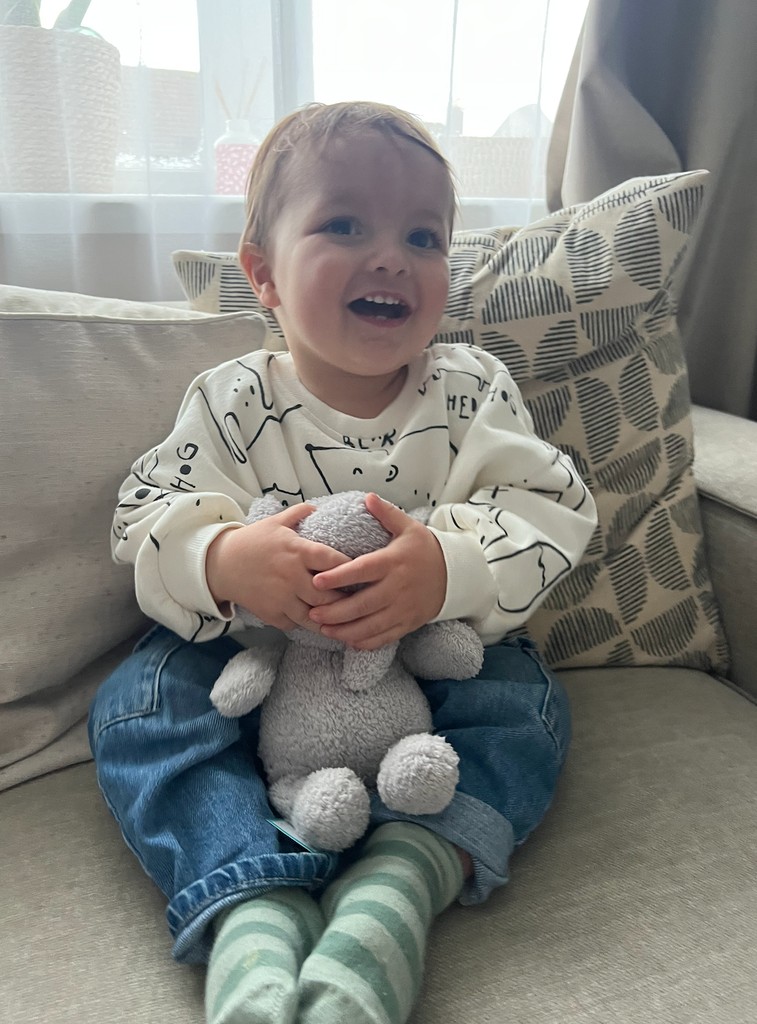 young boy sitting on sofa with elephant teddy