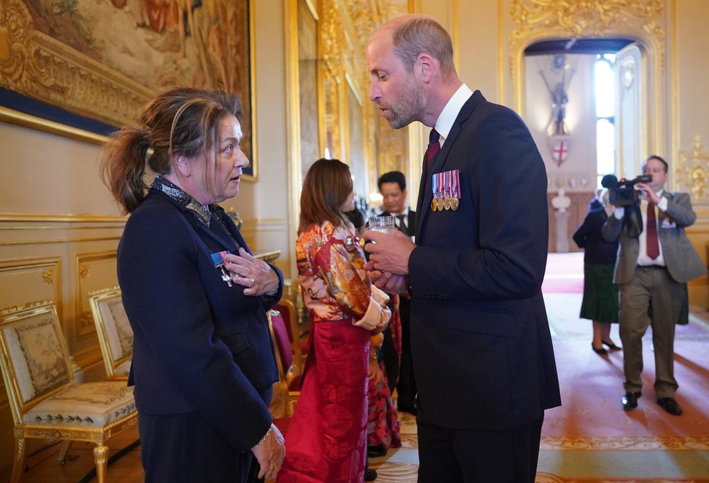 Prince Wiliam in smart attire talking to a woman inside Windsor Castle at a royal engagement