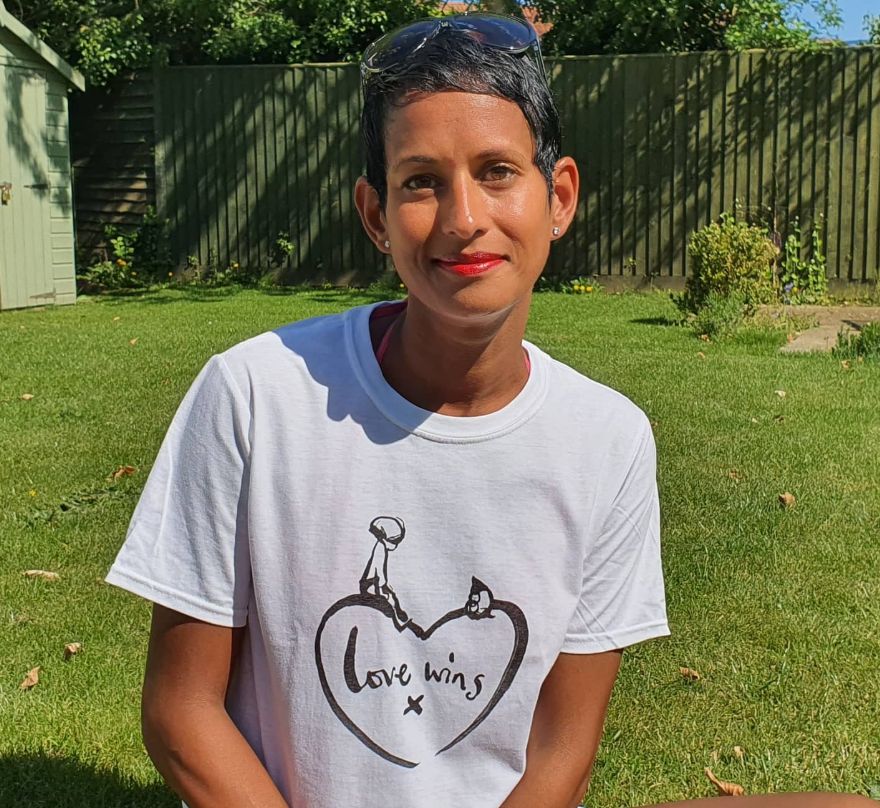 Naga Munchetty sitting in her garden with a shed to her side