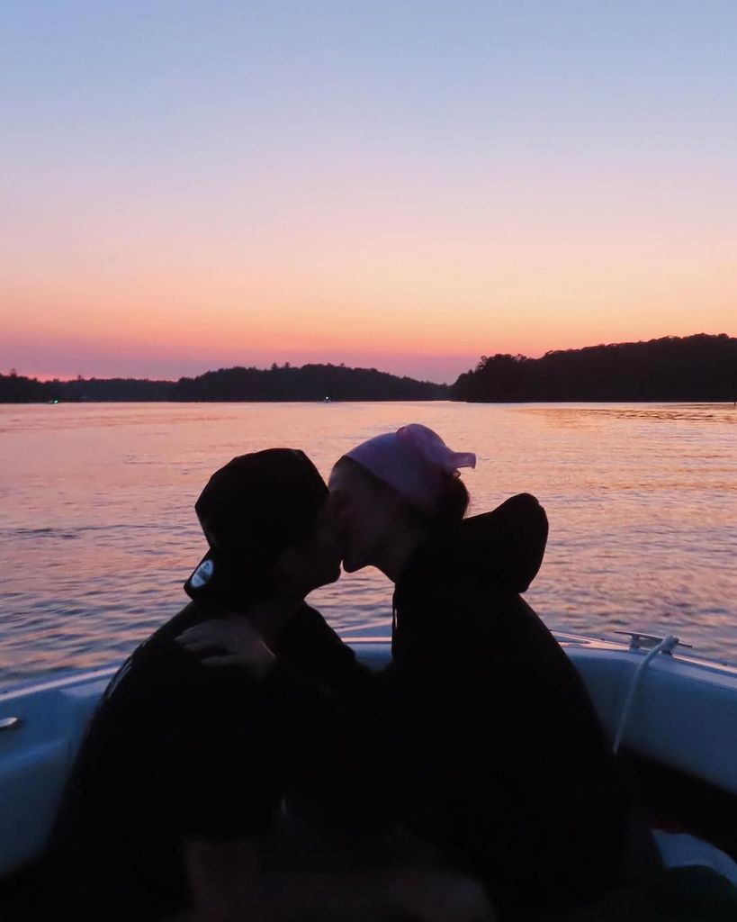 Nicola Peltz and Brooklyn Beckham kissing on a boat at sunset