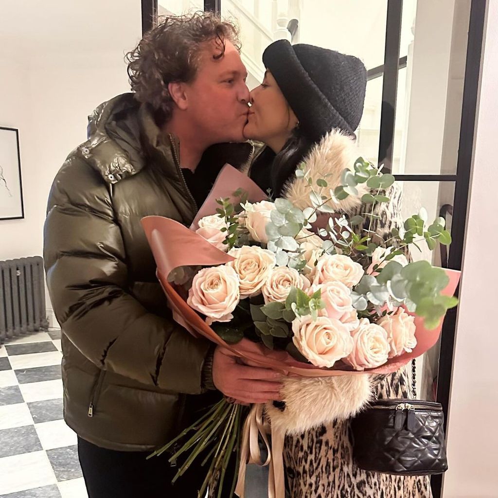 Martine McCutcheon kissing her husband and holding flowers