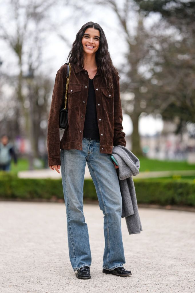 Model wearing jeans, ruched loafers, and brown suede jacket