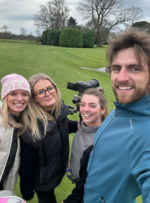 Three women and a man on a golf course