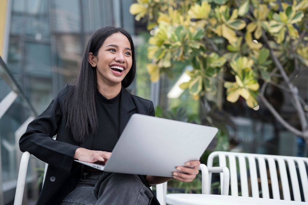 Young woman laughing on a laptop