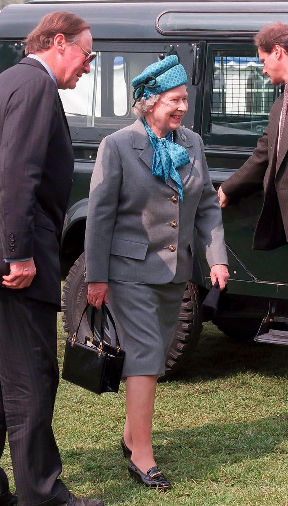 Rainha Elizabeth em exposição de cavalos em terno de saia cinza