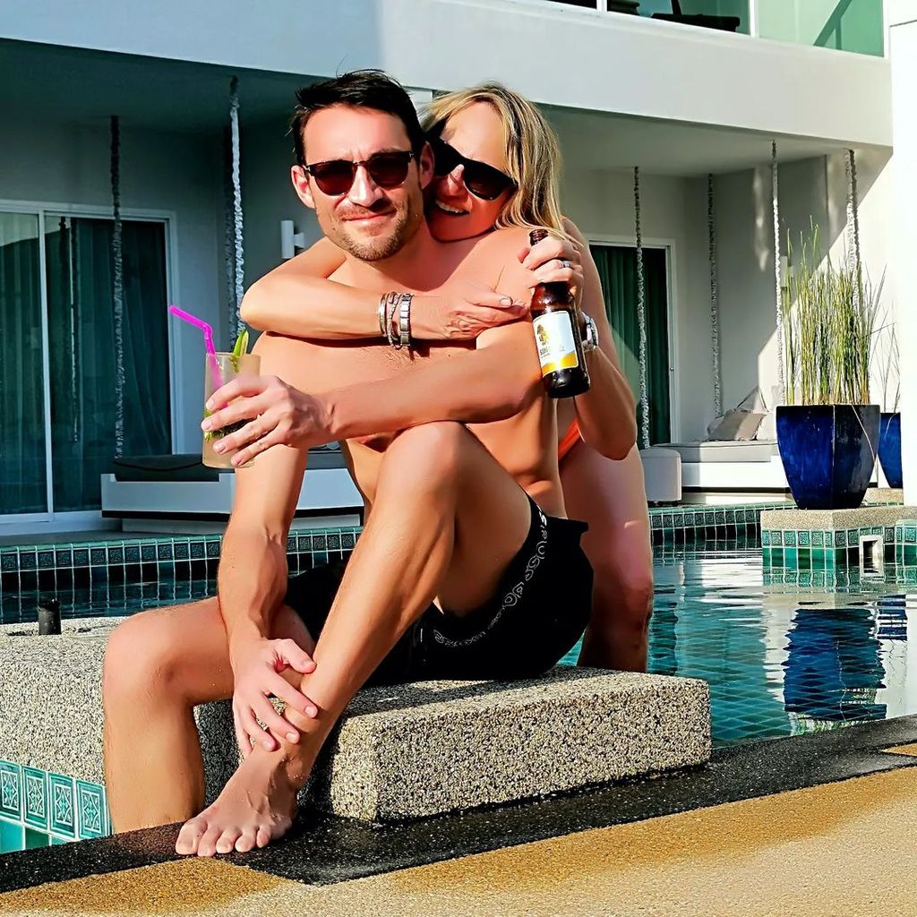 Carol in a bikini hugging her husband Mark next to the pool