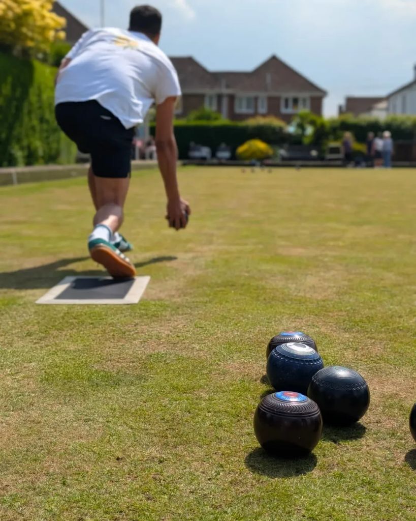 Will Kirk doing lawn bowls in a white top and black shorts