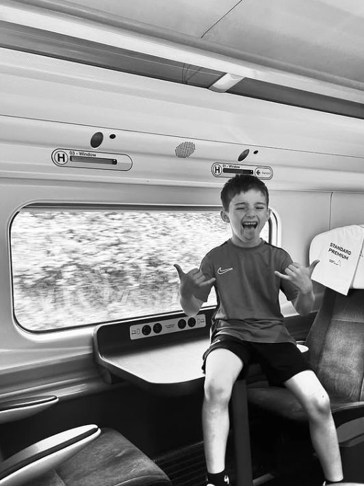 A young boy sitting on a table on a train
