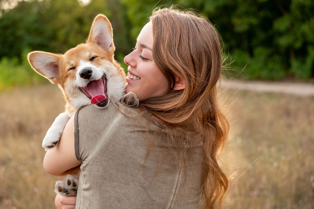 young woman with corgi puppy, nature background