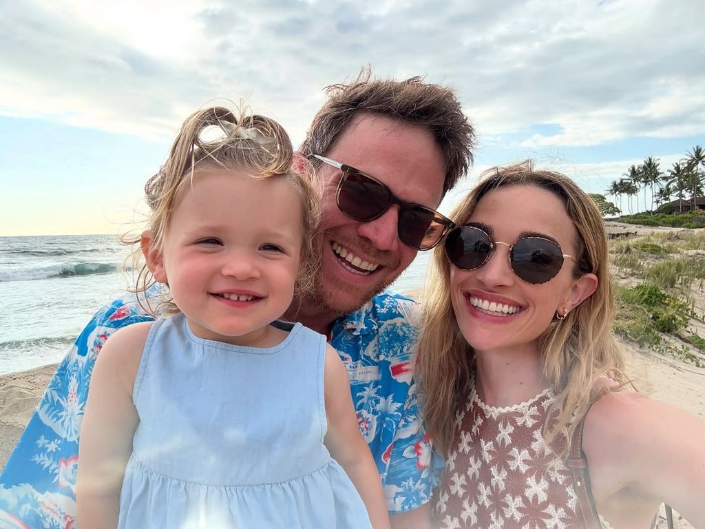 The family smiling on the beach in a selfie