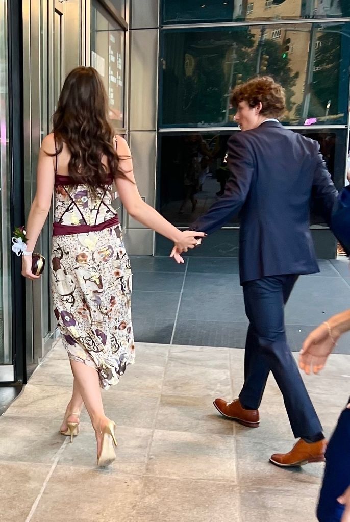 Suri helds hands with her date at their prom