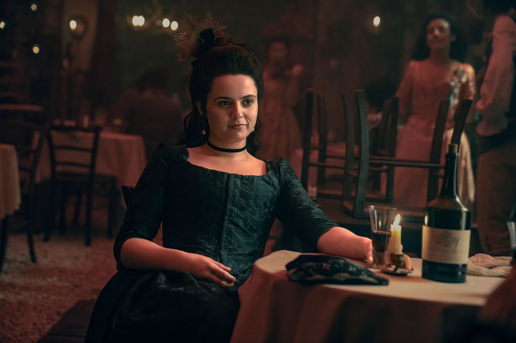 woman in period dress sitting on white-cloth table