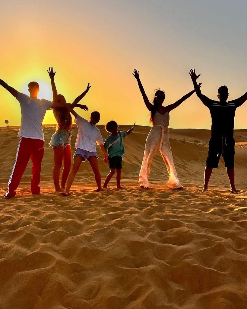 Peter Andre and his family posing on a sand dune 