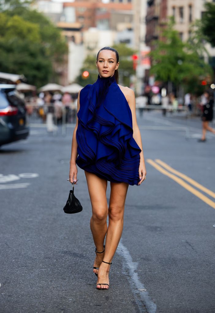 Jurga Fulti wears blue backless dress Alaia, black bag, heels on the way to Alaia during New York Fashion Week on September 06, 2024 in New York City. (Photo by Christian Vierig/Getty Images)