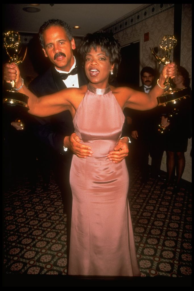 Stedman Graham hugging Oprah Winfrey, as she shows off the two Emmy awards she won for best TV talk show & best host at the Daytime Emmy Awards, 1995