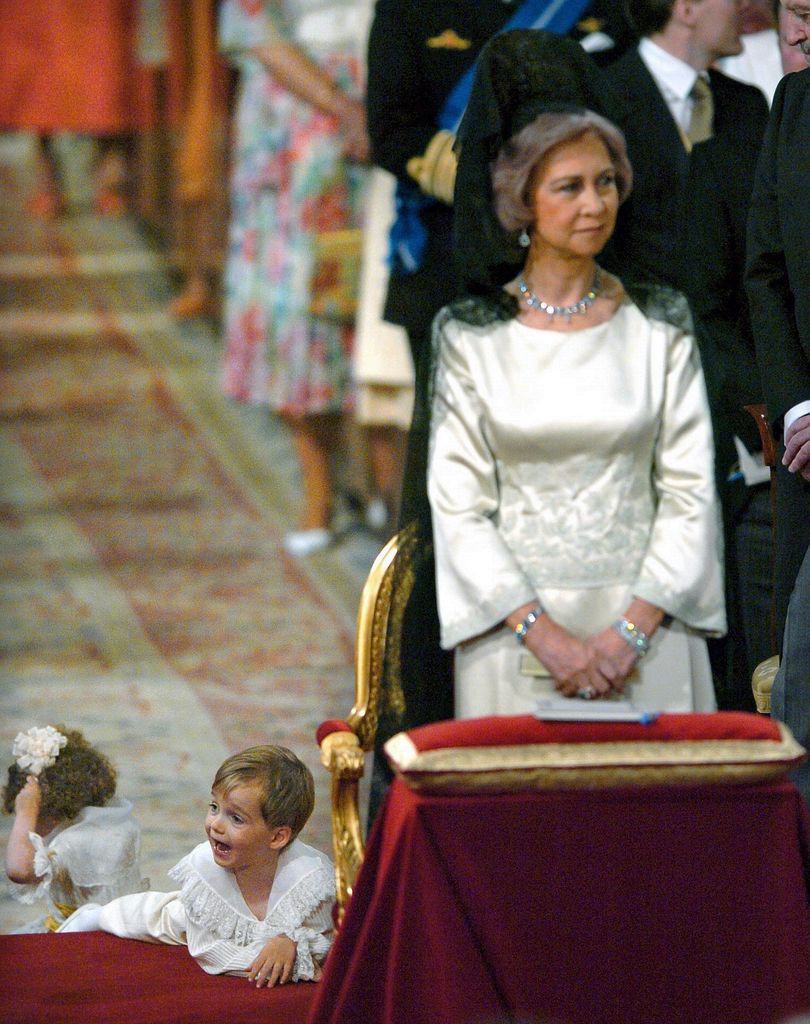 Queen Sofia standing next to page boys lying on the floor at Queen Letizia's wedding