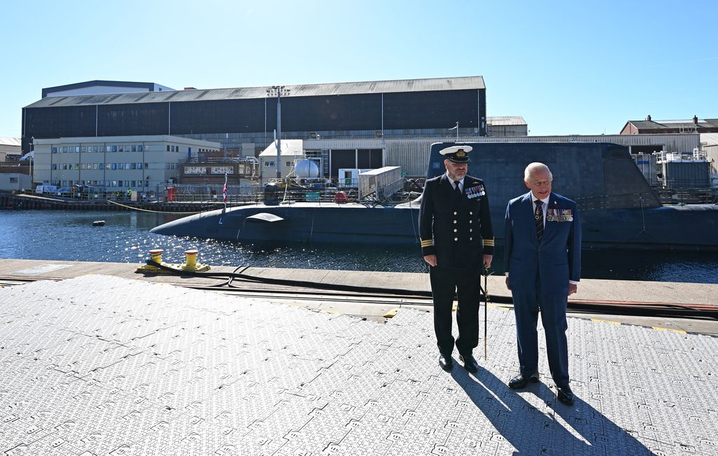 King Charles III talks with Commanding Officer David Crosby beside submarine in sea