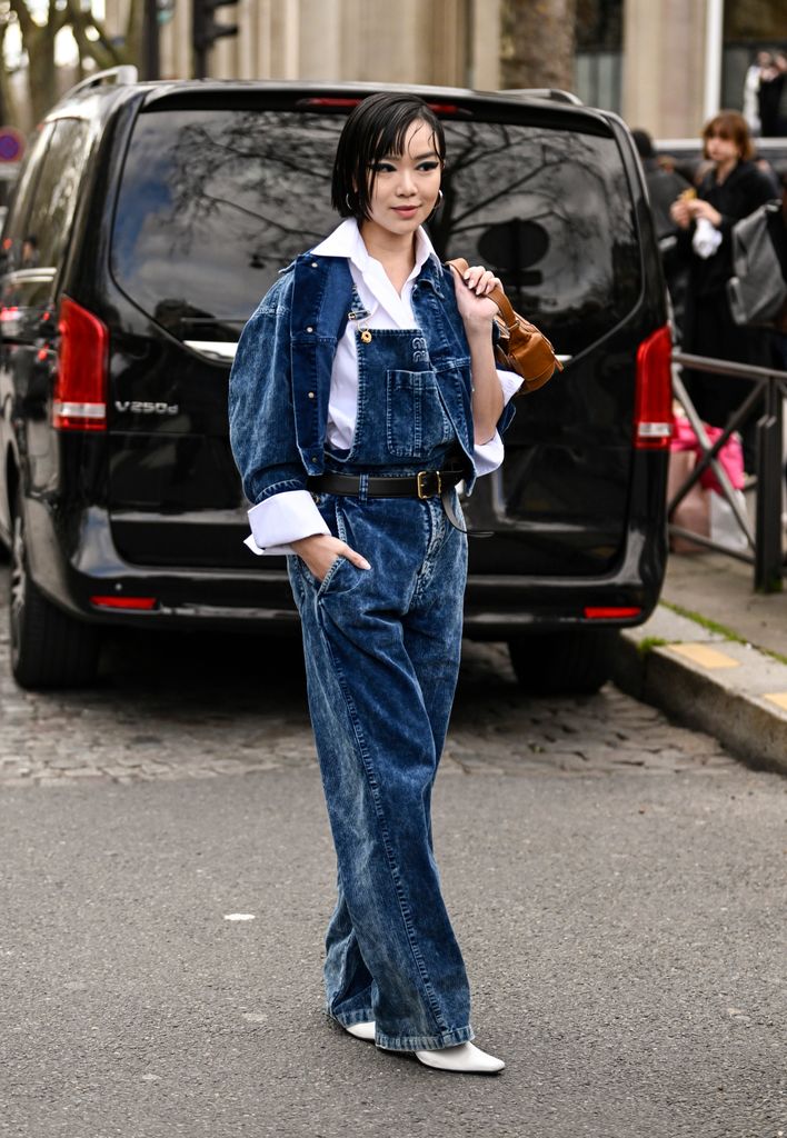 Willabelle Ong wears MiuMiu for their AW25 show - she teamed denim dungarees with a white shirt and denim jacket