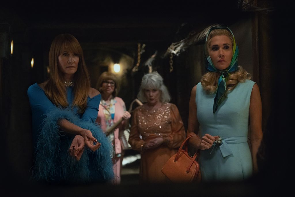 Four women stand in a dark corridor 