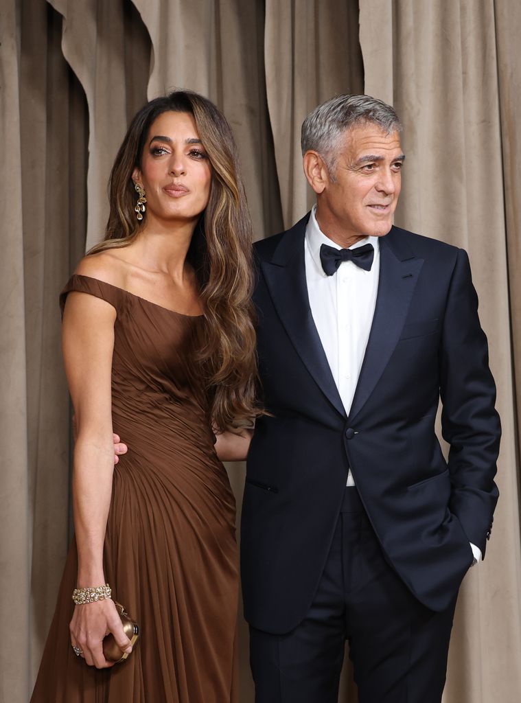 photo of amal clooney in brown dress beside george clooney in black suit