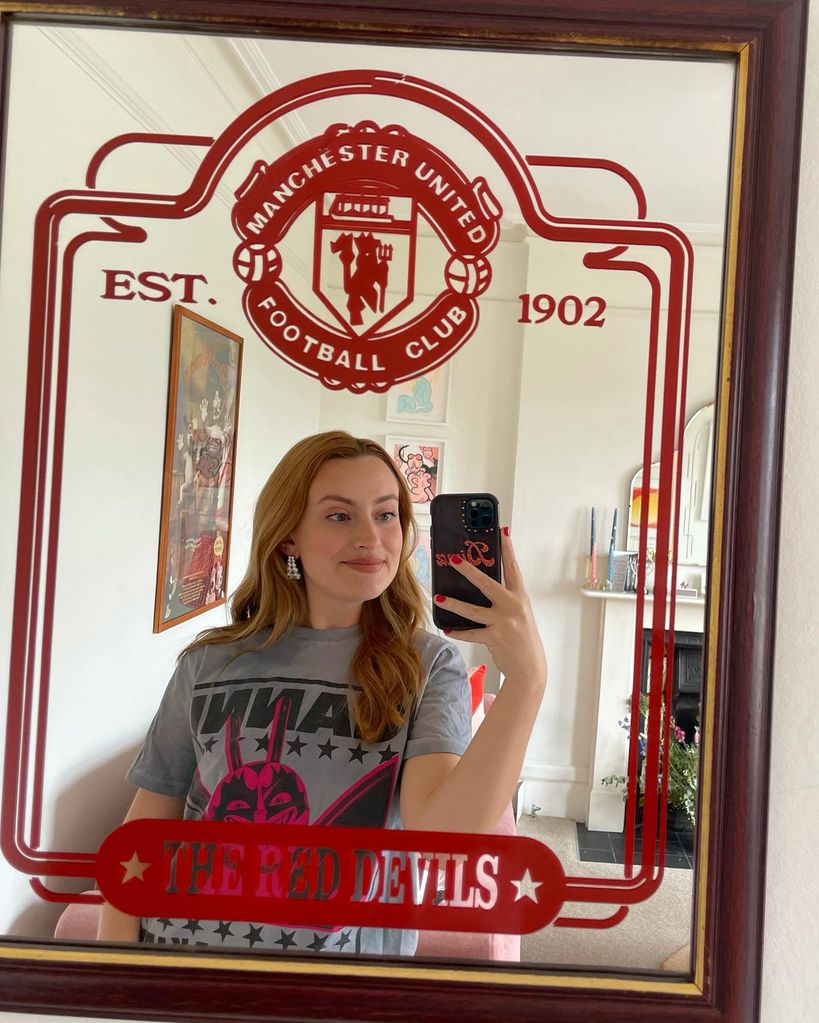 Amelia Dimoldenberg takes a photo in a Manchester United mirror