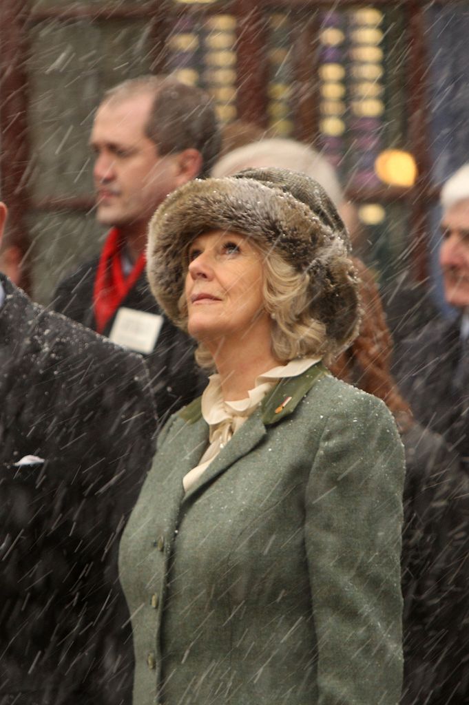 Queen Camilla in a fluffy hat looking at the snow