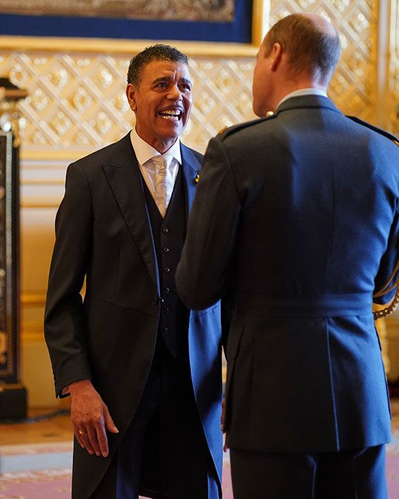 Chris Kamara receiving MBE from Prince William