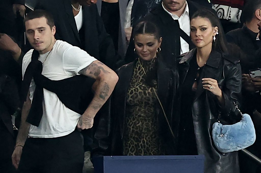 Brooklyn Beckham (L) and US singer and actress Selena Gomez (C) leave after attending the French L1 football match 